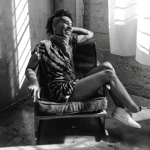 Person sitting comfortably by a window, looking calm and relaxed.